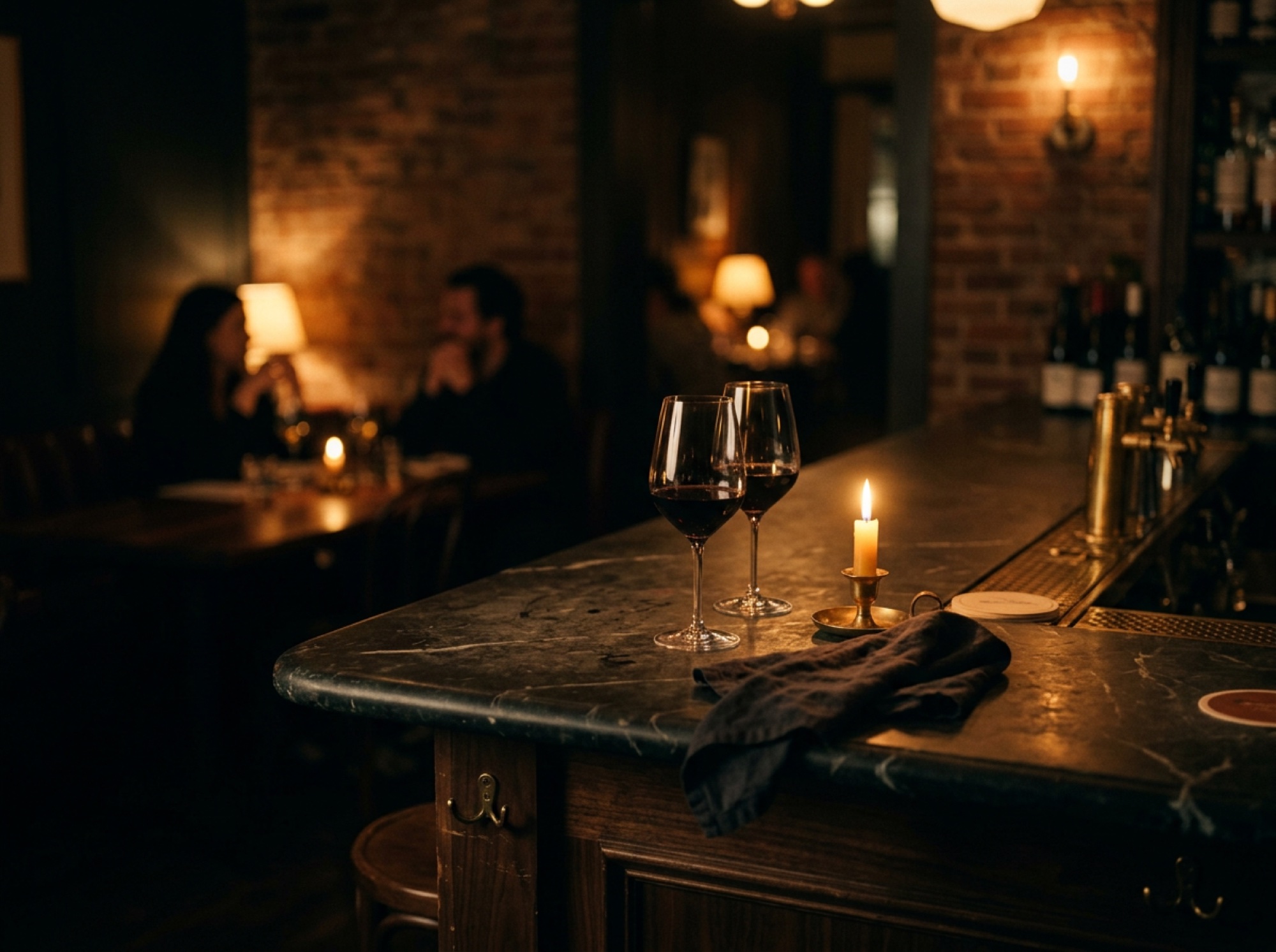 A warm dining room at night with brick walls, lamps and diners in soft focus